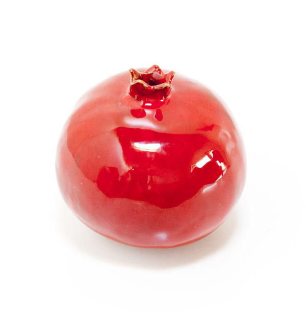 Immagine di melagrana di ceramica colore rosso su sfondo bianco