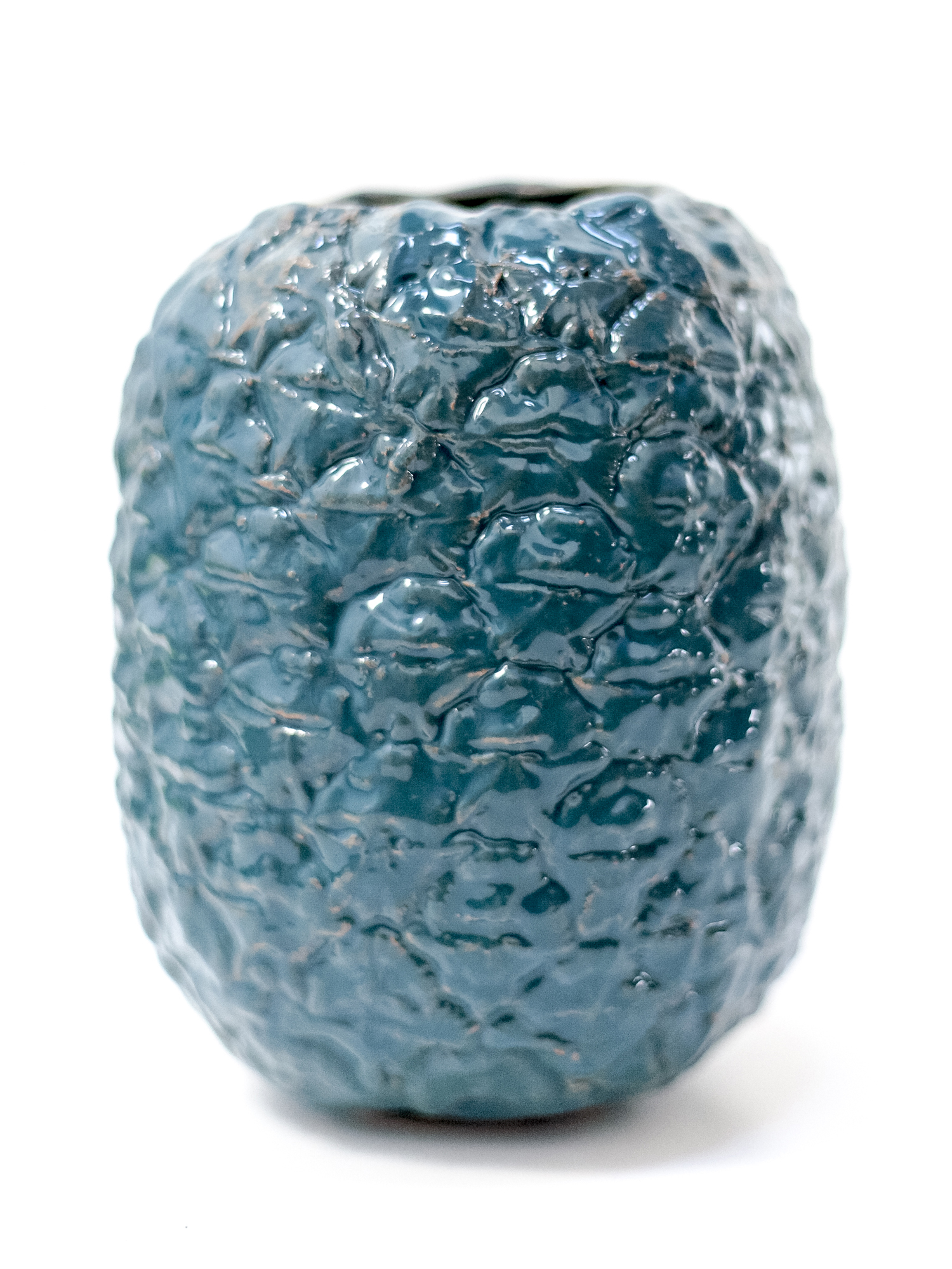 Immagine di vaso a forma di ananas di colore ottanio realizzato in ceramica su sfondo bianco.
