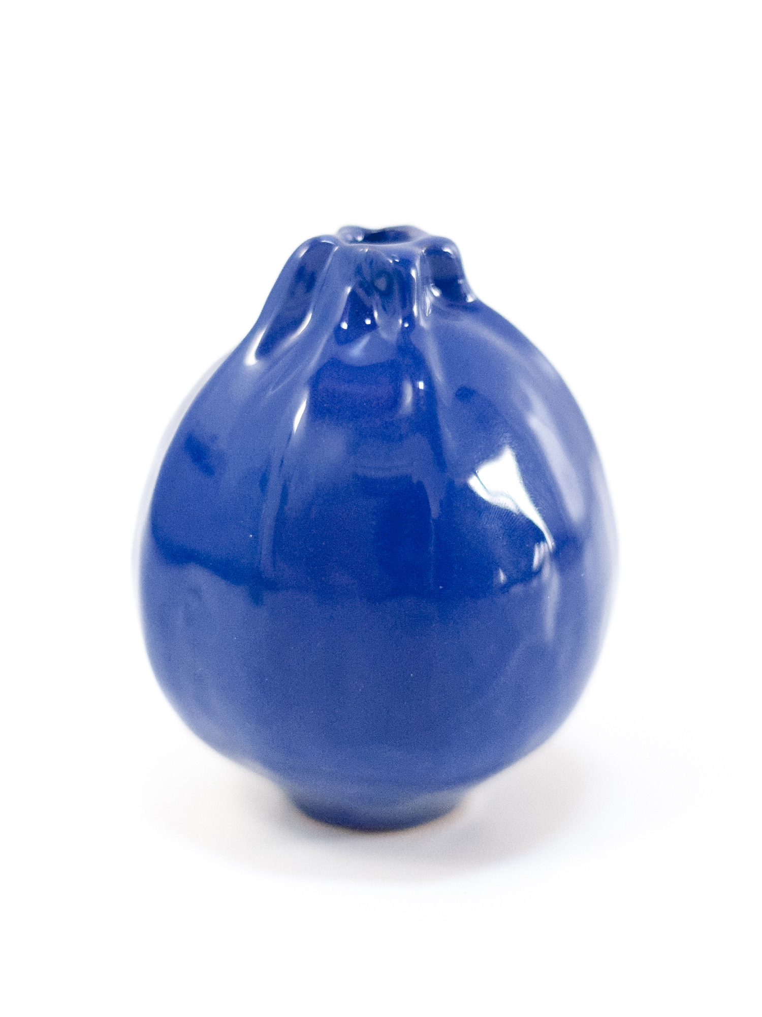 Zucchina di ceramica di colore blu su sfondo bianco.