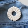 immagine di spila corolla in ceramica bianca su jeans blu