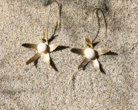 immagine di orecchini Stella Marina in ottone e porcellana su sabbia