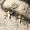 immagine di orecchini Stella Marina realizzati a mano in ottone e porcellana su sfondo sabbia