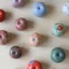 immagine di mele in ceramica colorate realizzate a mano in ceramica su sfondo colore legno chiaro