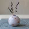 immagine di mela campanina fatta a mano in ceramica, colore lilla con cuoricini arancioni. Variante Ada